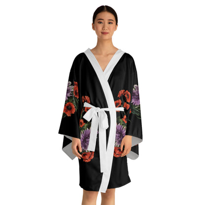 Woman wearing a black kimono-style robe with floral patterns on a white background