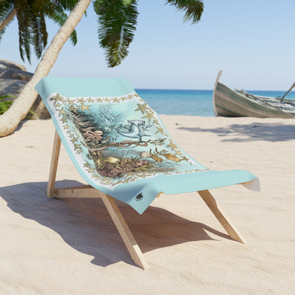 Beach chair with a towel featuring ocean life design on a sandy beach.